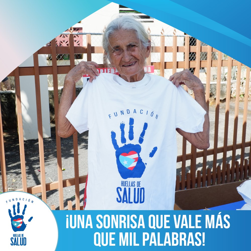 Voluntaria de la fundación sosteniendo una camiseta de Huellas de Salud